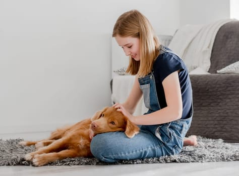 11-Year-Old Girl Plays With Nova Scotia Retriever Toller At Home On The Floor