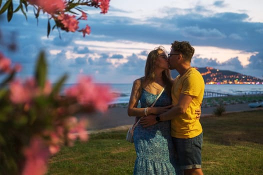 Happy couple taking a photo on a beach at the sea in Alanya city, Turkey. Focus on the background. Travelling or vacation concept