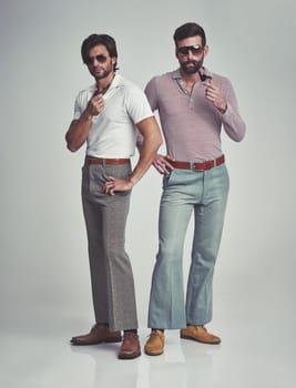 Vintage, men and sunglasses or pipe in studio with fashion model, hipster outfit or confidence with calm expression. Friends, people and attitude with 70s style or retro clothes with white background.