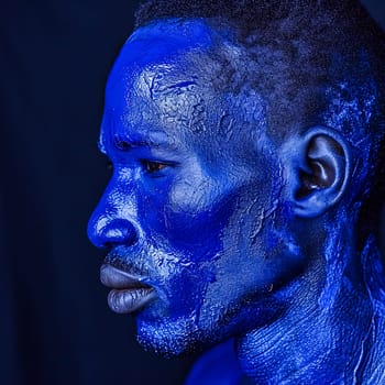 In a stunning display of creativity, an African man adorned in vibrant blue paint captivates viewers with his striking appearance in a captivating photograph.
