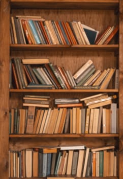 Shelf Filled With Old Books, Vintage Charm And Nostalgic Appeal Of Aged Literature. Weathered Book Spines And Aged Pages, Evoking Sense Of History And Literary Heritage. Vertical Close-Up Shot. High quality photo