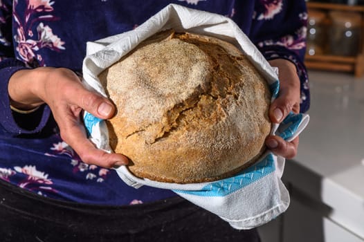 Woman holding homemade whole grain bread in her hands 6