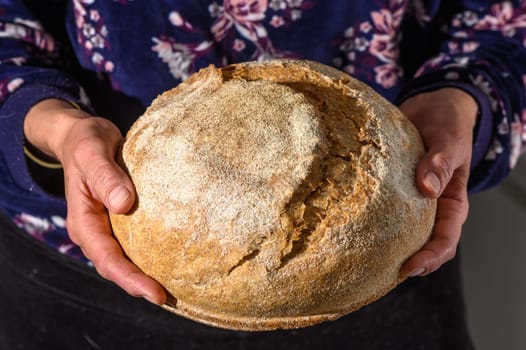 Woman holding homemade whole grain bread in her hands 5