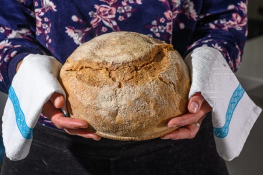 Woman holding homemade whole grain bread in her hands 4