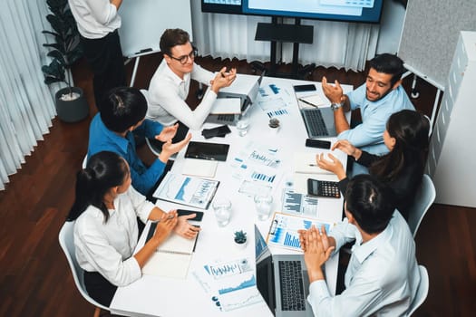 Analyst team utilizing BI Fintech to analyze financial data at table in meeting room. Businesspeople analyzing BI dashboard power for business insight and strategic marketing planning. Prudent