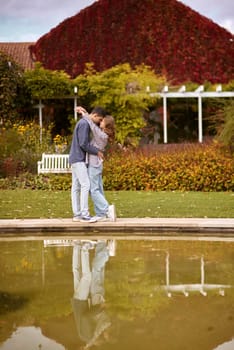 lovely young couple kissing outdoors in autumn. Loving couple walking in nature. Autumn mood. Happy man and woman hugging and kissing in autumn. Love. Fashionable couple outdoors. Fashion, people and lifestyle. Stylish couple in autumn outfit.