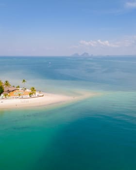 Drone aerial view at Koh Muk a tropical island in Trang Thailand, palm trees and soft white sand, and a turqouse colored ocean in Koh Mook Trang Thailand