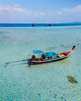 longtail boat in the turqouse colored ocean with clear water at Koh Kradan a tropical island in Trang Thailand