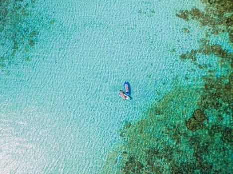 Asian woman at peddle board sup at Koh Kradan a tropical island in Thailand, Top down view picture of a woman paddling on the sup board.