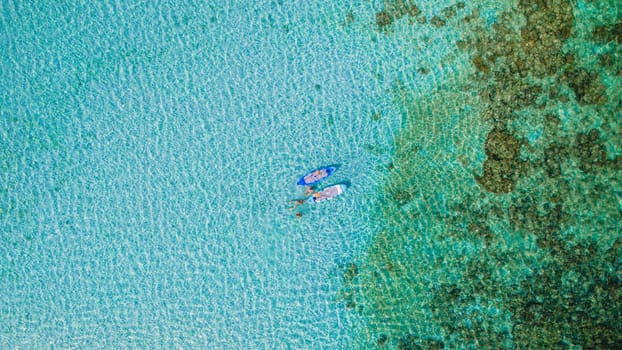 Asian woman at peddle board sup at Koh Kradan a tropical island in Thailand, Top down view picture of a woman paddling on the sup board.