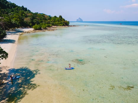 woman at peddle board sup at Koh Kradan a tropical island in Thailand.