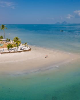 Drone aerial view at Koh Muk a tropical island with palm trees and soft white sand, and a turqouse colored ocean in Koh Mook Trang Thailand on a sunny day