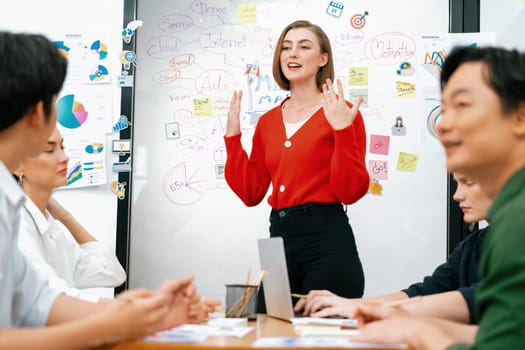 Professional attractive female leader presents creative marketing plan by using brainstorming mind mapping statistic graph and colorful sticky note at modern business meeting room. Immaculate.