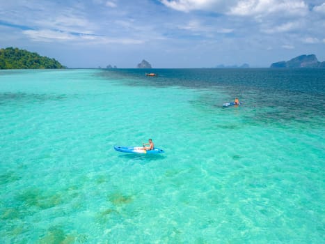 Young men in a kayak at the bleu turqouse colored ocean of Koh Kradan Thailand, a tropical island with a coral reef in the ocean, Koh Kradan Trang Thailand