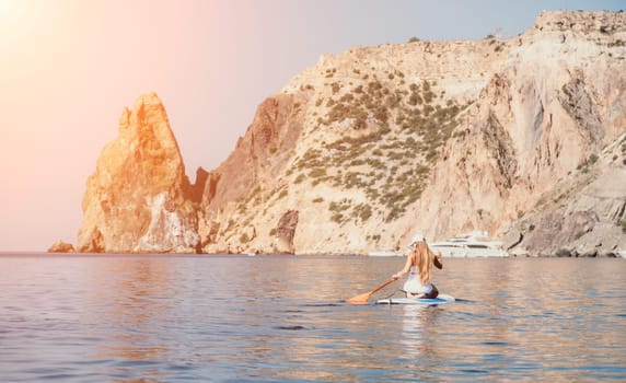 Close up shot of beautiful young caucasian woman with black hair and freckles looking at camera and smiling. Cute woman portrait in a pink bikini posing on a volcanic rock high above the sea