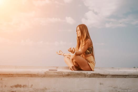 Woman park yoga. Side view of free calm bliss satisfied woman with long hair standing in morning park with yoga position against of sky by the sea. Healthy lifestyle outdoors in park, fitness concept