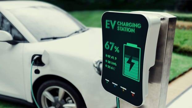 Electric car recharging with EV charger from charging station at public car park. Future innovative rechargeable EV car using alternative clean and sustainable energy. Peruse