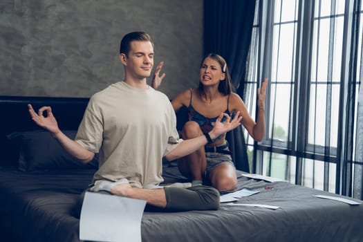 Young man doing mindfulness and peacefulness meditation ignoring problem while his wife or lover yelling with frustrated and upset expression. Marriage problem ignorant lifestyle. Unveiling