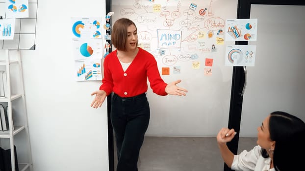 Young beautiful caucasian businesswoman presenting marketing strategy by using mind map, graph while answering questions with confident. Teamwork, brainstorming, discussing concept. Immaculate.