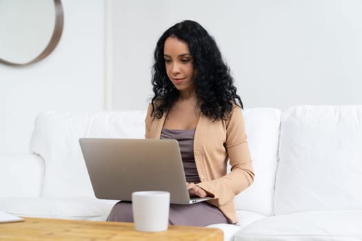 African-American woman using laptop computer for crucial work on internet. Secretary or online content writing working at home.