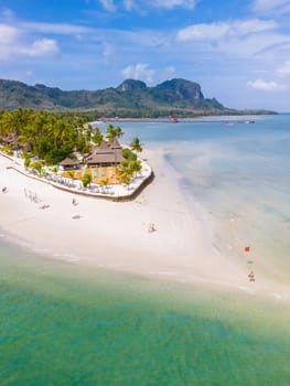 Drone aerial view at Koh Muk a tropical island with palm trees and soft white sand, and a turqouse colored ocean in Koh Mook Trang Thailand