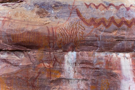 Ancient cave art depicting animals and tribal symbols.