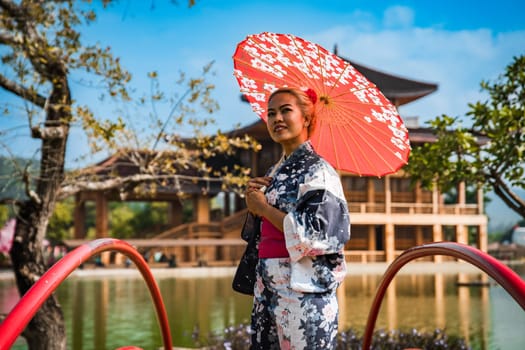 Asian girl in kimono and umbrella in Japanese theme park Hinoki Land in Chai Prakan District, Chiang Mai