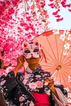 Asian girl in kimono and umbrella in Japanese theme park Hinoki Land in Chai Prakan District, Chiang Mai