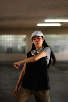 Shot of young beautiful girl performing breakdance moves in parking lot.