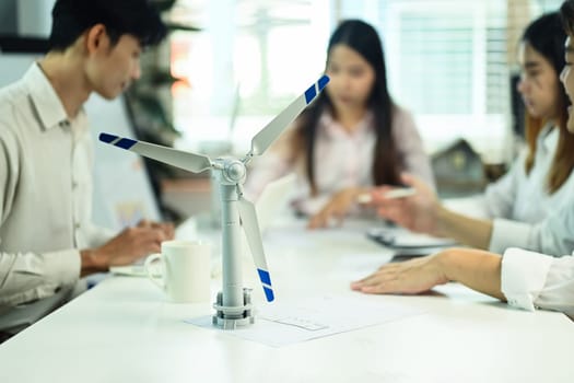 Wind turbine model on a meeting table. Alternative energy and Sustainability development concept.