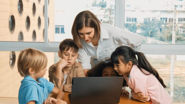 Cute african girl programing system while surround with caucasian teacher and diverse friend. Professional instructor explain and teaching coding engineering prompt while student listening. Erudition.