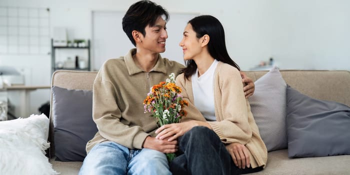 Young couple Hug and giving flower on Valentine's Day. Romantic day together. Valentine's Day concept.