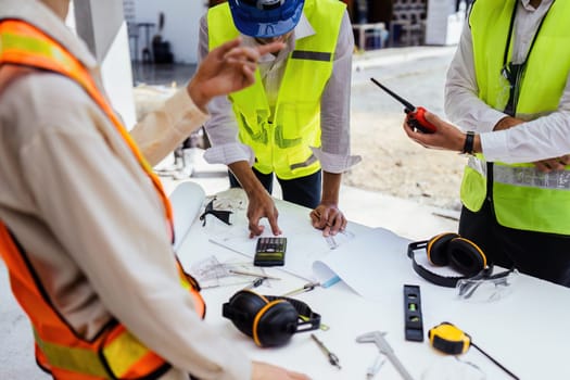 team engineer, foreman, architect meeting for colleagues discussing and checks construction blueprints at onsite.