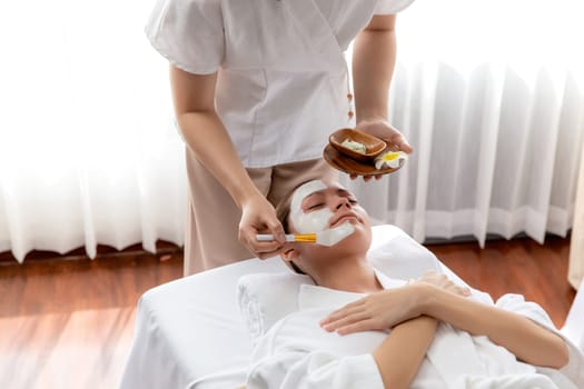 Serene ambiance of spa salon, woman customer indulges in rejuvenating with luxurious face cream massage with modern daylight. Facial skin treatment and beauty care concept. Quiescent