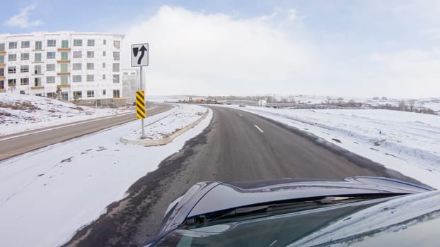 Centennial, Colorado, USA-January 30, 2023-Navigating a frontage road post-winter storm offers a serene drive. The surrounding landscape, blanketed in snow, contributes to the peaceful and picturesque environment, enhancing the driving experience.