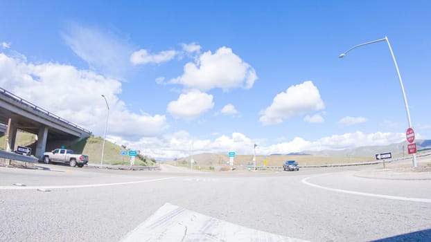 Santa Maria, California, USA-December 6, 2022-On a crisp winter day, a car cruises along the iconic Highway 101 near San Luis Obispo, California. The surrounding landscape is brownish and subdued, with rolling hills and patches of coastal vegetation flanking the winding road.