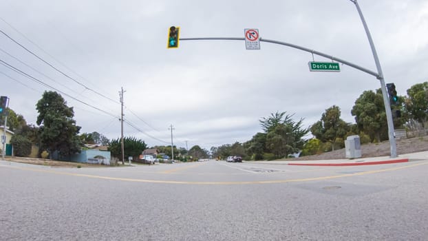 Santa Maria, California, USA-December 6, 2022-Vehicle navigates the streets of Morro Bay, California, during a cloudy winter day. The atmosphere is moody and serene as the overcast sky casts a soft light on the charming buildings and quiet streets of this coastal town.