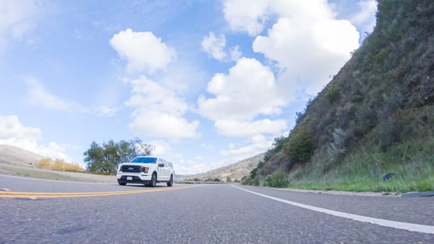 Santa Maria, California, USA-December 6, 2022-Vehicle is cruising along the Cuyama Highway under the bright sun. The surrounding landscape is illuminated by the radiant sunshine, creating a picturesque and inviting scene as the car travels through this captivating area.