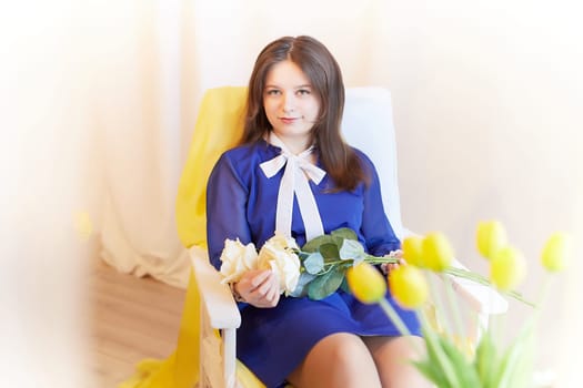 Beautiful sweet manager girl in romantic business dress with fresh flowers in office. Young businesswoman on International Women's Day on March 8