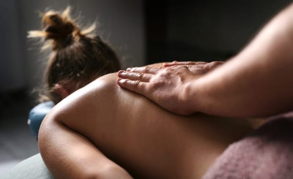 Relax Massage Procedures In A Beauty Salon, Professional Masseure Doing Back Massage For Young Girl