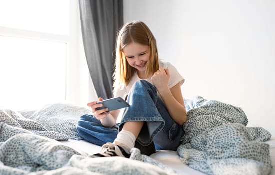 Cute Little Won The Game On A Smartphone, Playing On A Bed In Kid'S Room