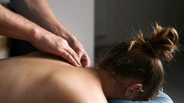 Massage Therapist Massaging Back Of Young Girl In A Massage Spa Salon, Procedures For Health Spine And Back Muscles