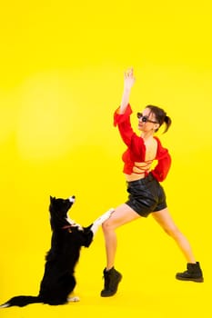 Beautiful sport female with border collie in a studio