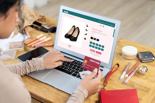 Woman shopping online on internet marketplace browsing for sale items for modern lifestyle and use credit card for online payment from wallet protected by crucial cyber security software