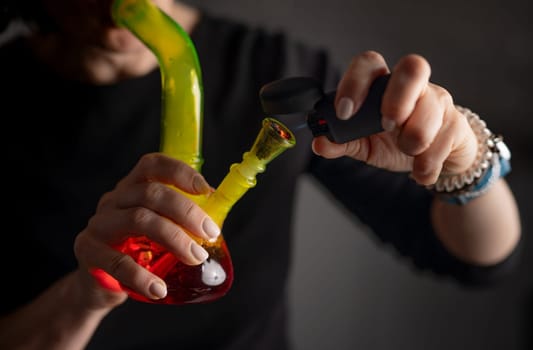 Burning And Smoking Hemp Leaves From A Bong, Flame Close-Up, With Female Hands