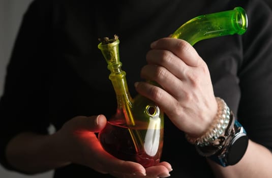 Woman Holds Bong For Smoking Cannabis In Close-Up View