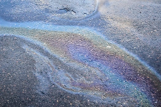 Spills of fuel or oil on the asphalt road as texture or background.