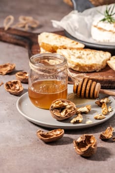 Brie type of cheese. Camembert cheese. Fresh sliced Brie cheese on a wooden tray with nuts, honey and leaves. Italian, French cheese.