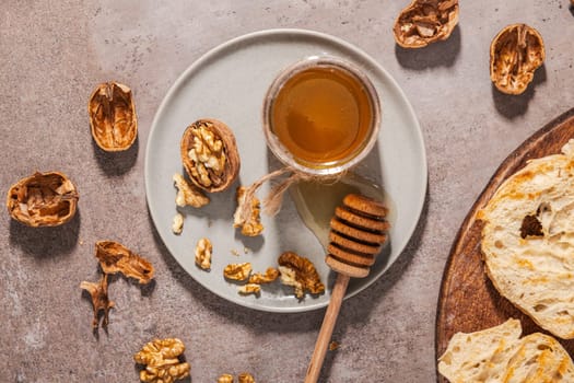Jar with honey on a rustic kitchen counter with nuts and bread toast