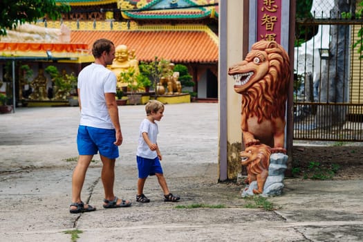 Father and son tourists walking in Vietnam Buddhist Temple, happy childhood, exploring world.